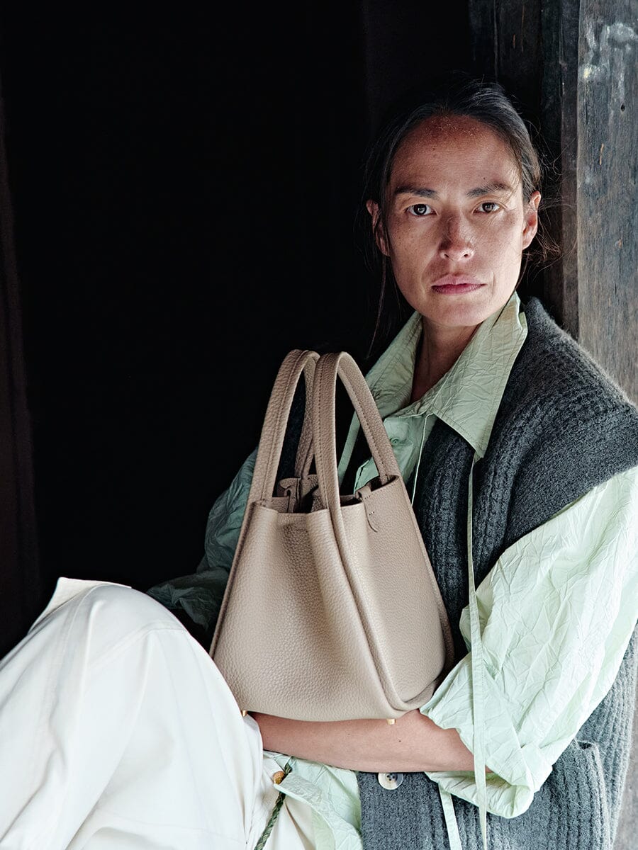 Songmont Medium Song Bag Cream Apricot portrait carrying the bag
