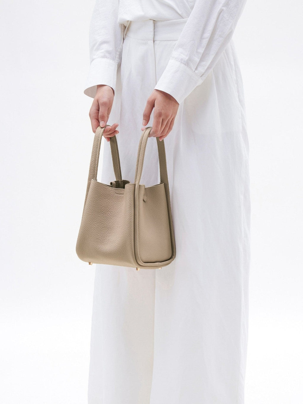Songmont Medium Song Bag Cream Apricot carried by the top handles