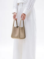 Songmont Medium Song Bag Cream Apricot carried by the top handles