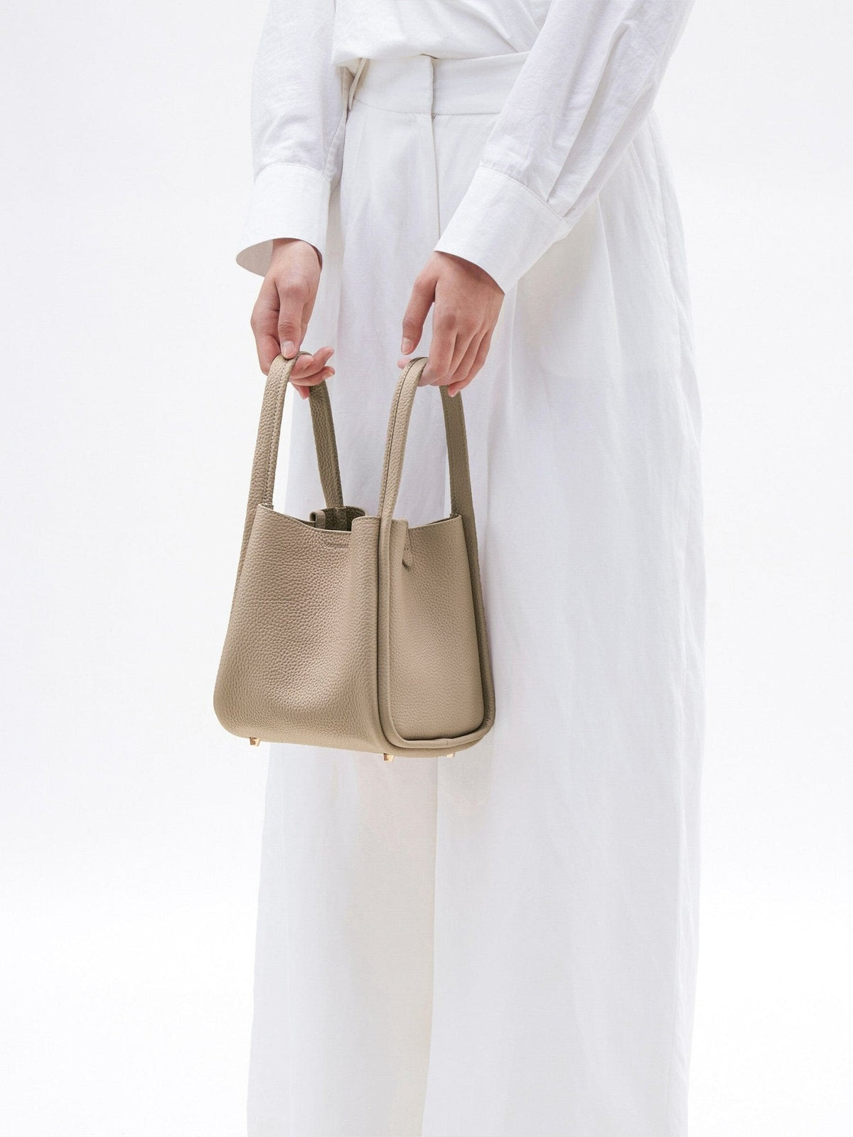 Songmont Medium Song Bag Cream Apricot carried by the top handles