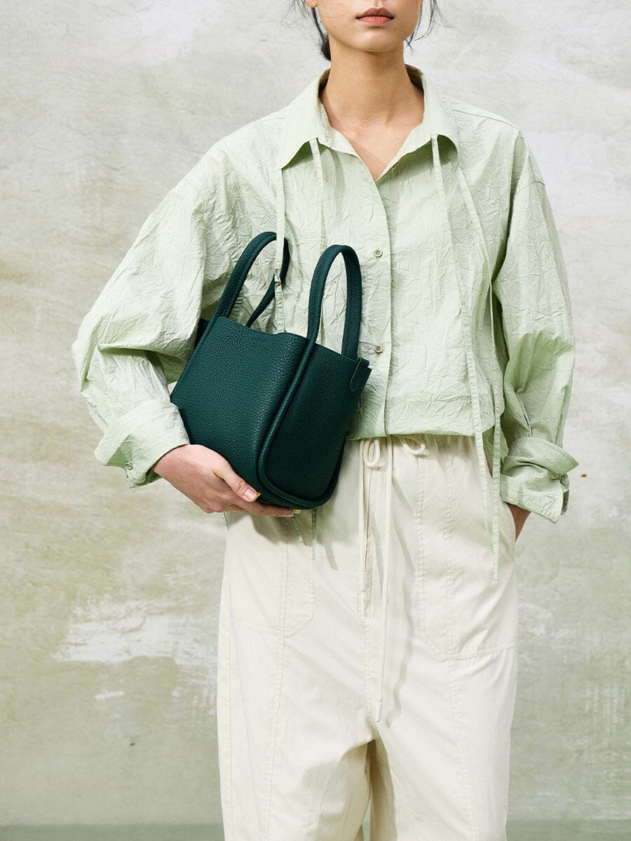 Songmont Medium Song Bag Emerald held in the arms