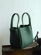 Songmont Medium Song Bag Emerald styled on a wooden stand