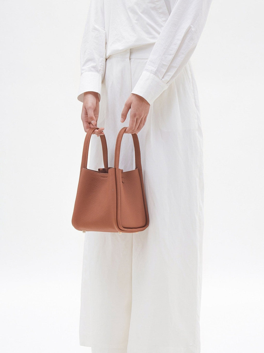 Songmont Medium Song Bag Golden Brown carried by the top handles