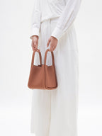 Songmont Medium Song Bag Golden Brown carried by the top handles