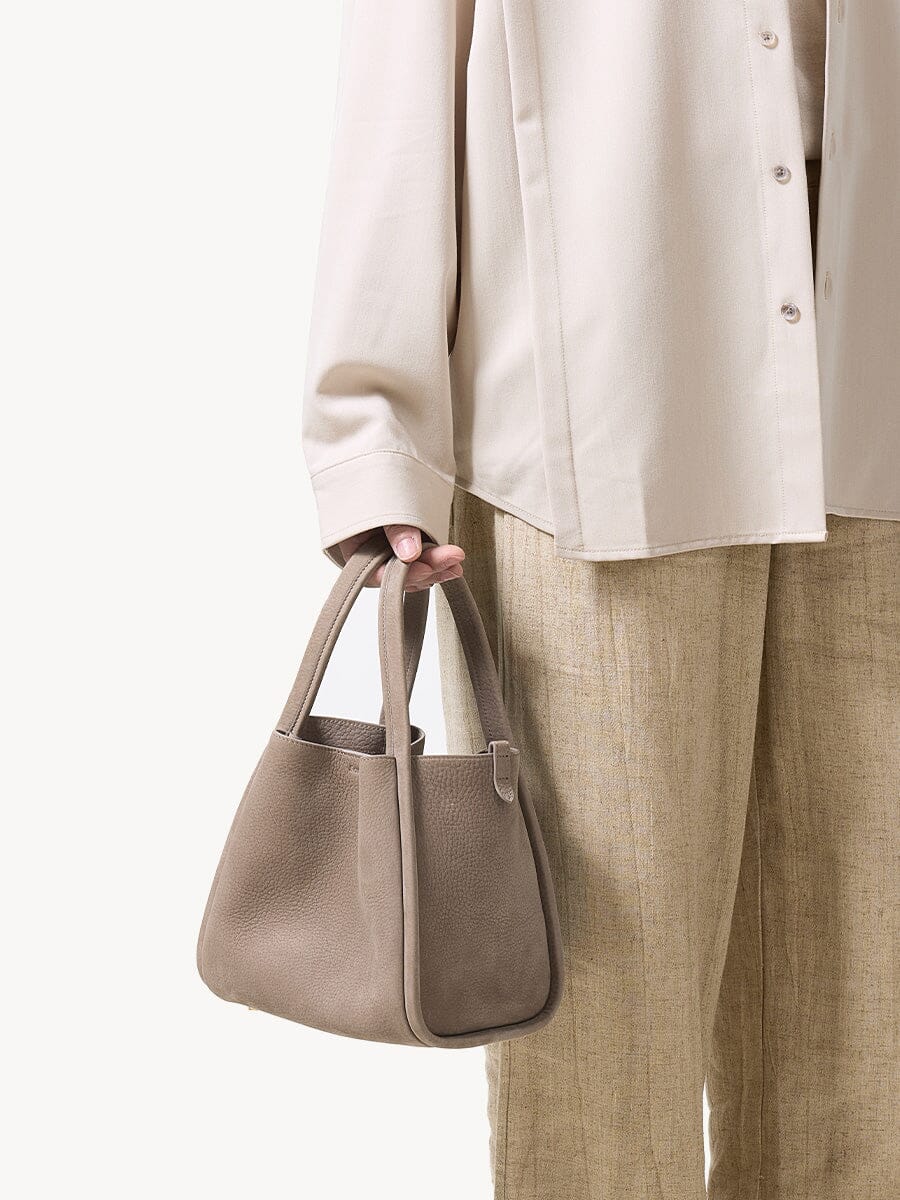 Songmont Medium Song Bag Haze carried by the top handles