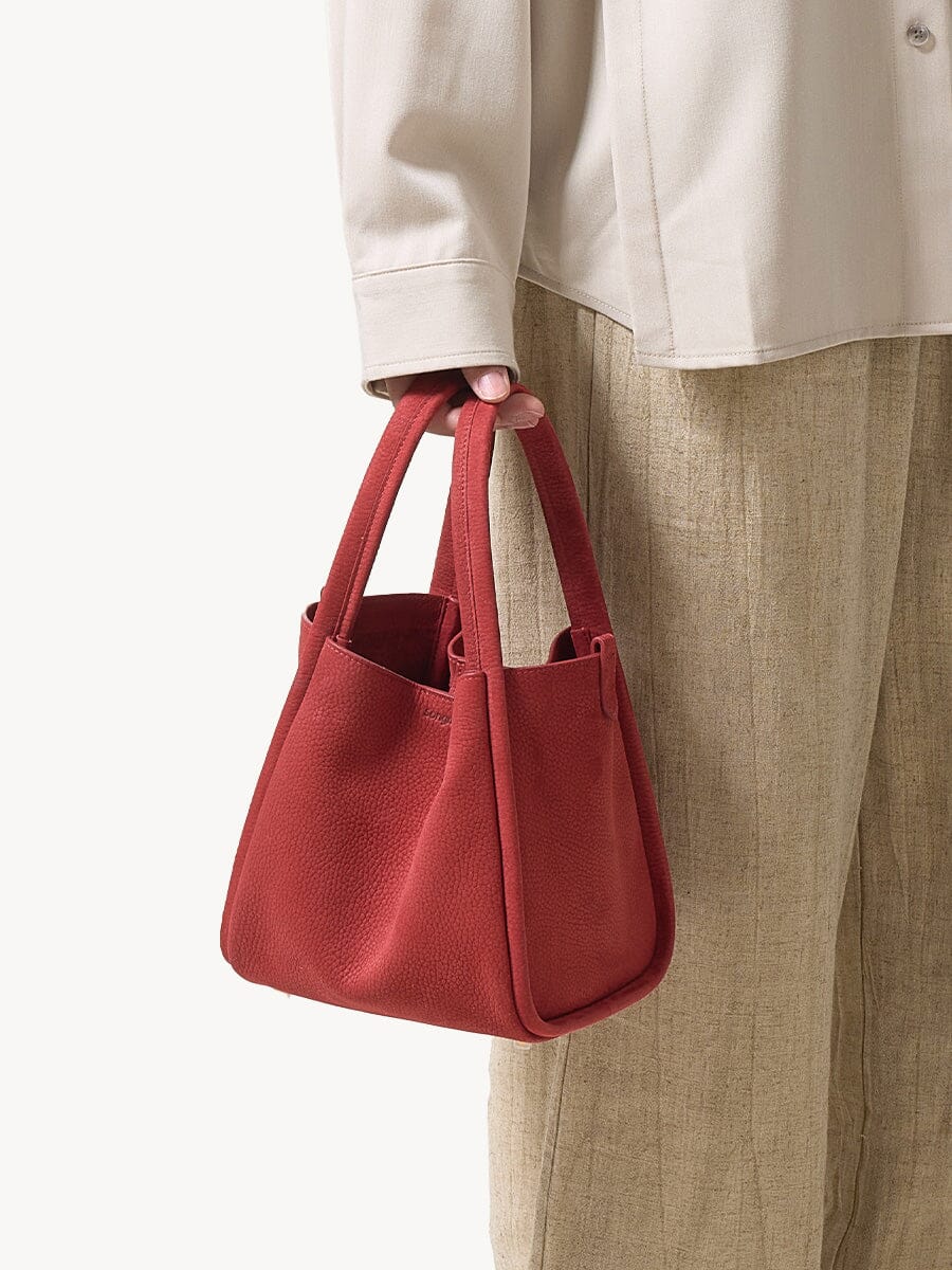 Songmont Medium Song Bag Poppy carried by the top handles