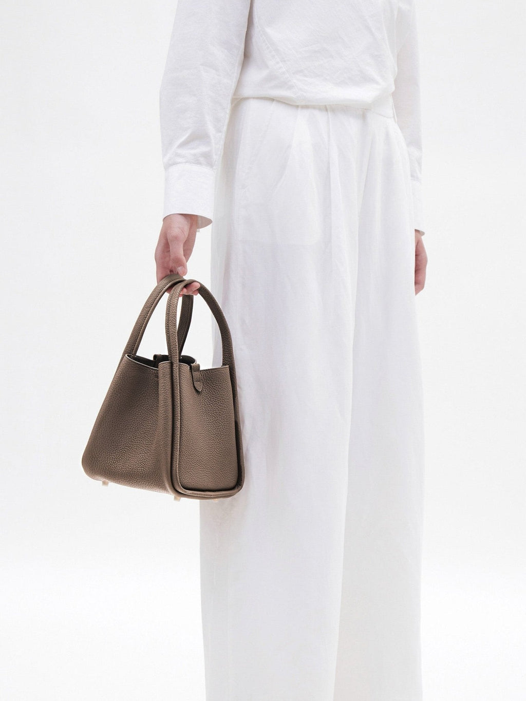 Songmont Medium Song Bag Taupe carried by the top handles