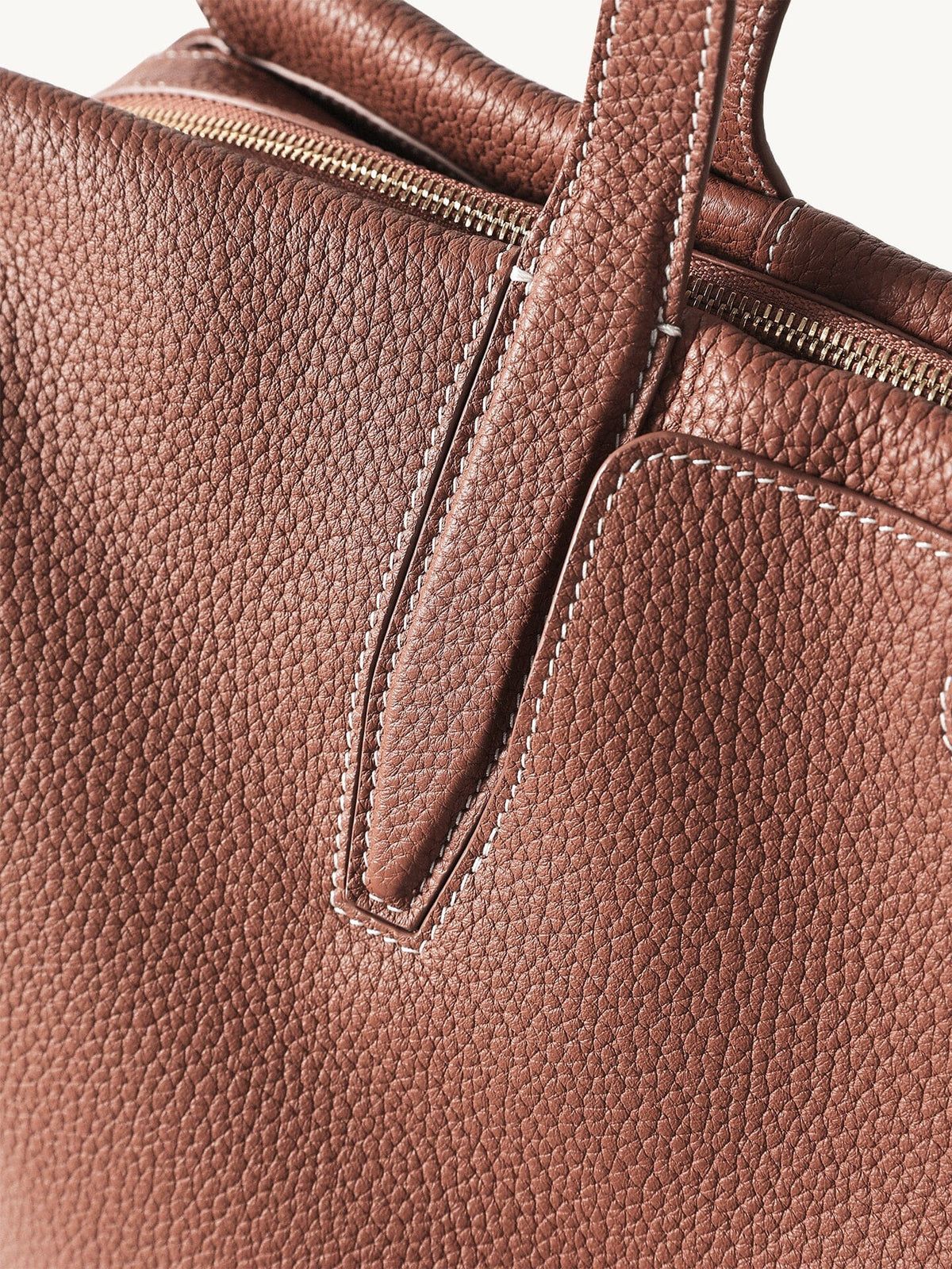 Songmont Medium Yore Duffle Bag Golden Brown - close-up of pebbled leather and handle tab