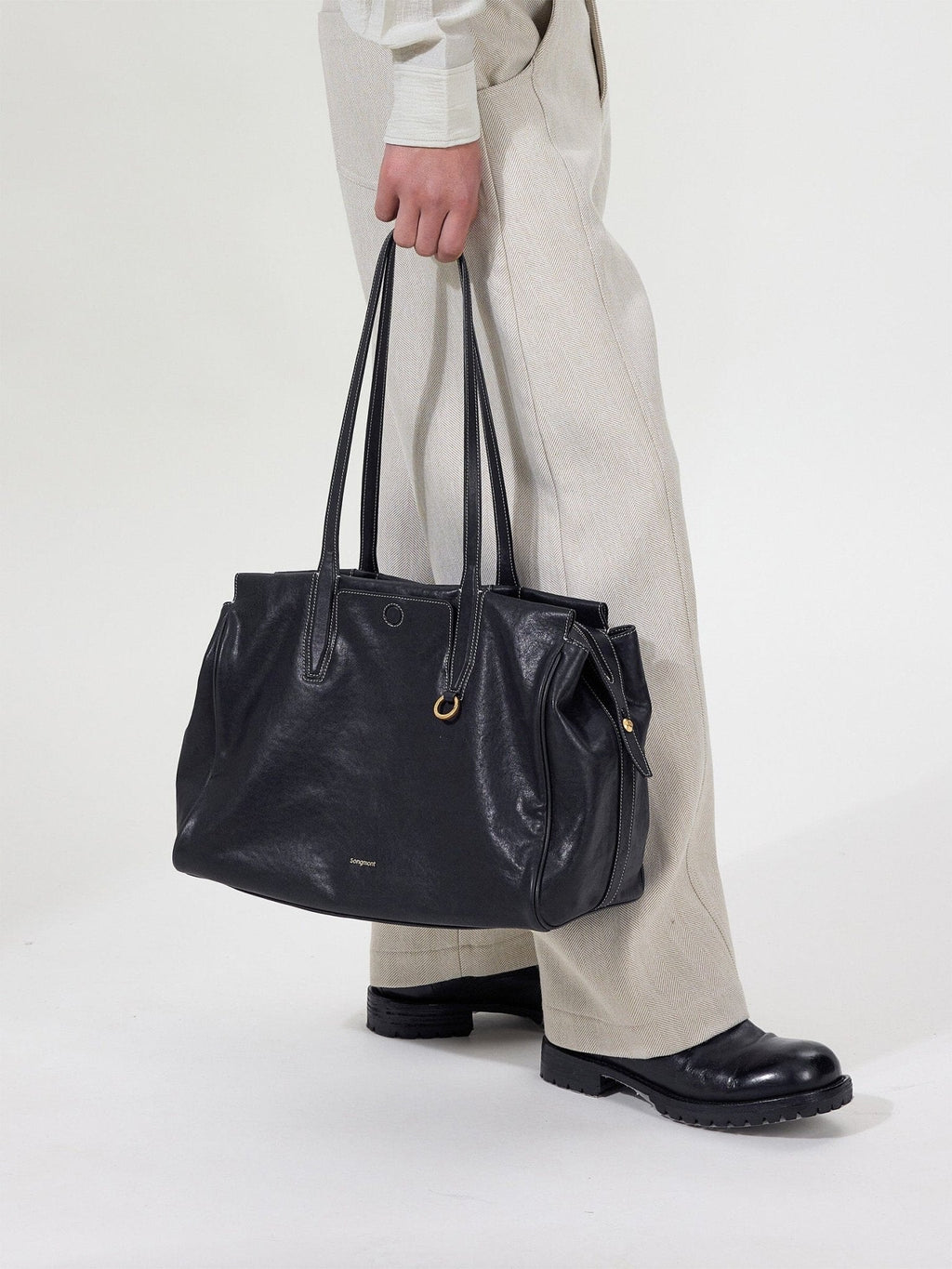Songmont Medium Yore Duffle Bag Onyx - carried by the handles, close view