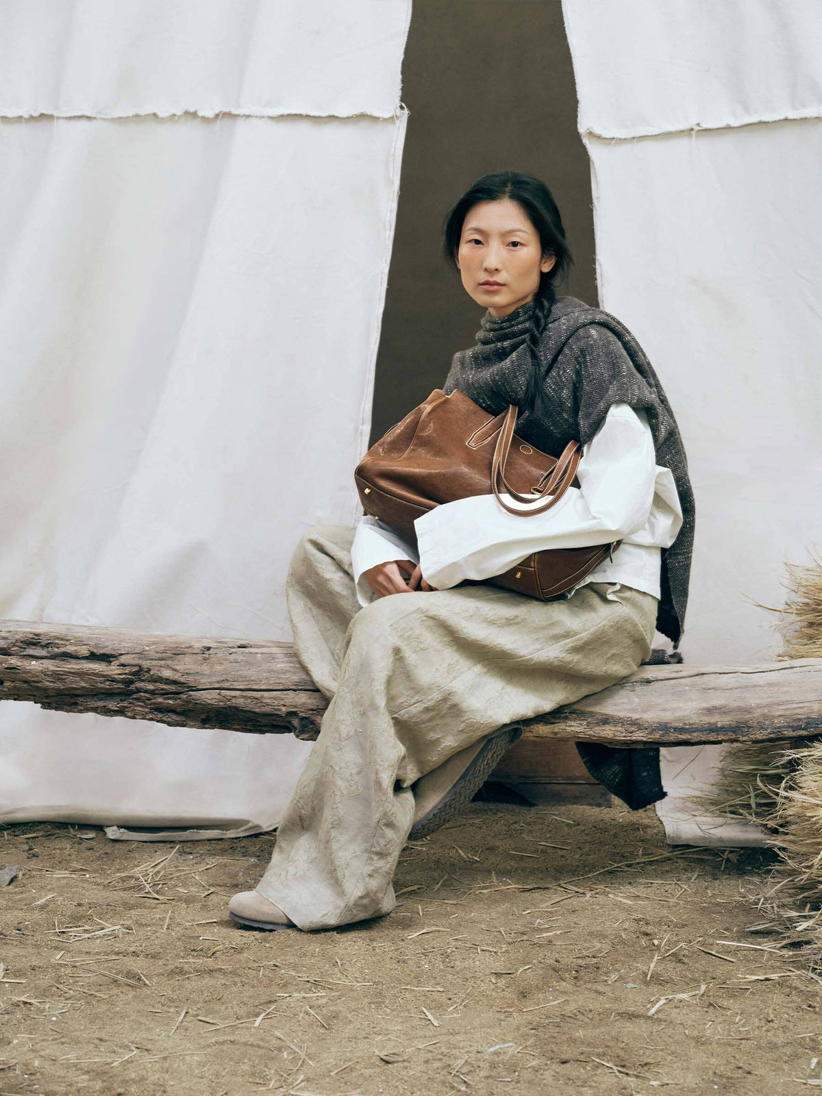 Songmont Medium Yore Duffle Bag Sandal - held on the lap by a seated model