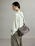 Songmont Medium Yore Hobo Bag Ink Grey worn on the shoulder