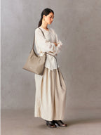 Songmont Medium Yore Shoulder Bag Smoke Grey - worn over the shoulder with a cream blouse