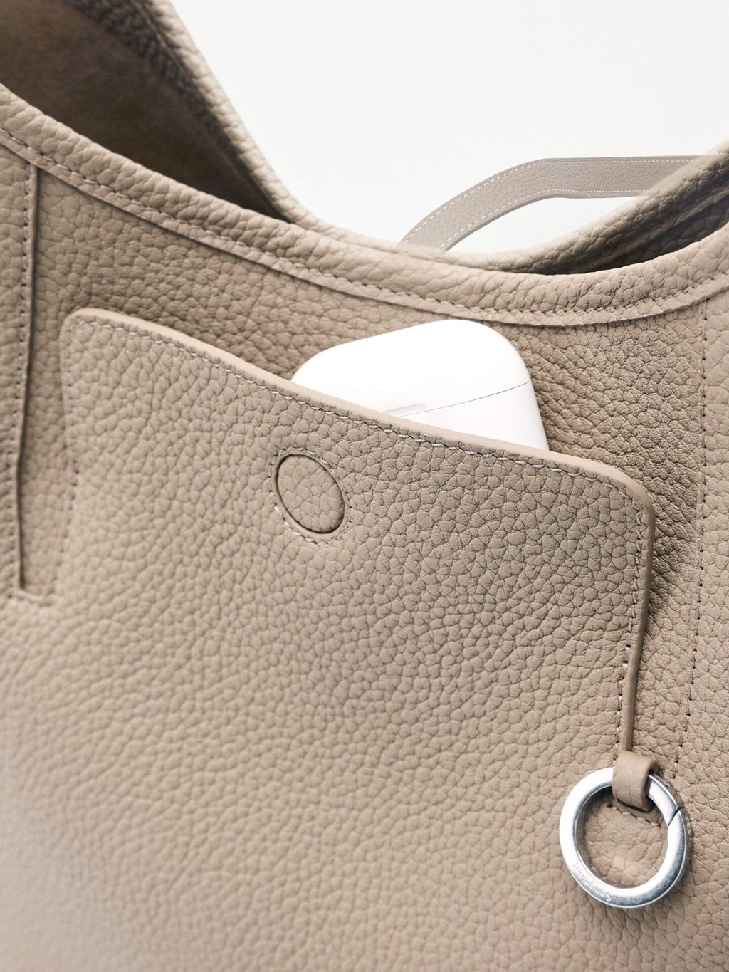 Songmont Medium Yore Shoulder Bag Smoke Grey - front pocket open with an AirPods case inside