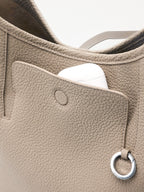 Songmont Medium Yore Shoulder Bag Smoke Grey - front pocket open with an AirPods case inside