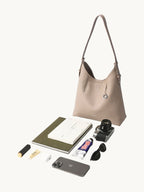 Songmont Medium Yore Shoulder Bag Smoke Grey - shown with everyday essentials laid out