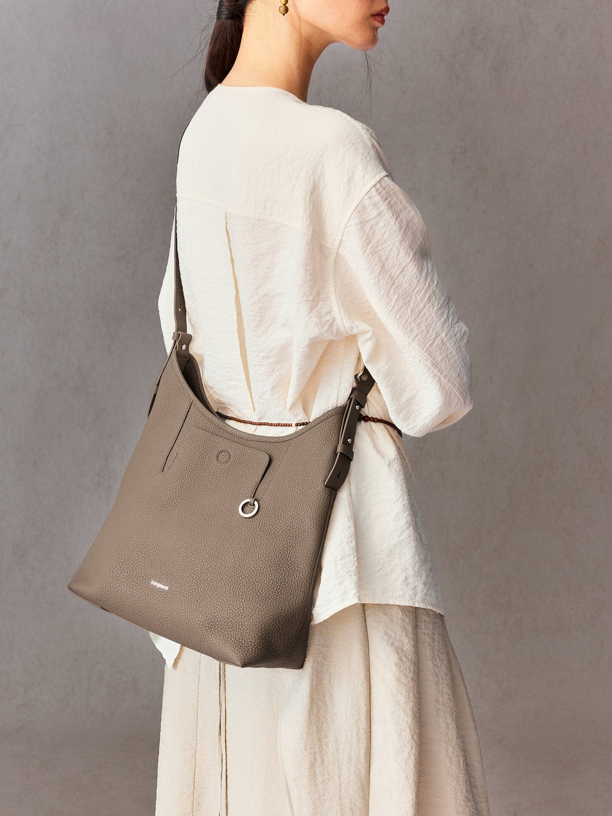 Songmont Medium Yore Shoulder Bag Stone - worn across the body, back view