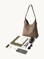 Songmont Medium Yore Shoulder Bag Stone - shown with everyday essentials laid out