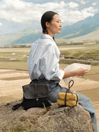 Songmont Mini Shan Backpack Onyx - styled on a rock in a mountain landscape