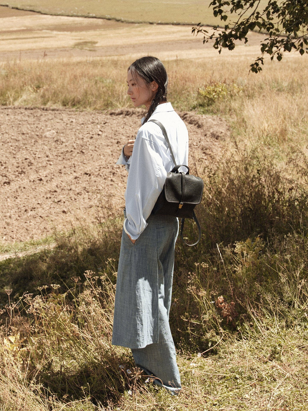 Songmont Mini Shan Backpack Onyx - worn on the back in a field