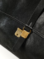 Songmont Mini Shan Backpack Onyx - close-up of gold buckle on flap strap