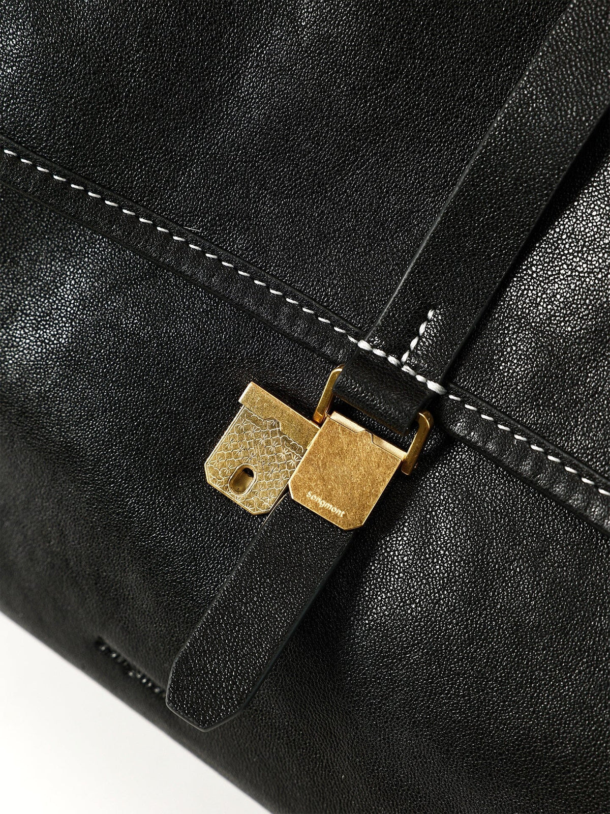 Songmont Mini Shan Backpack Onyx - close-up of gold buckle on flap strap