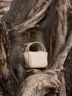 Songmont Mini Song Bag Ivory - styled against tree roots