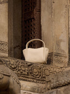 Songmont Mini Song Bag Ivory - styled on a carved ledge