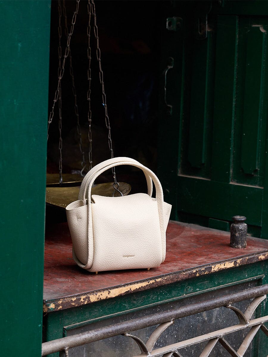 Songmont Mini Song Bag Ivory - styled against green doors