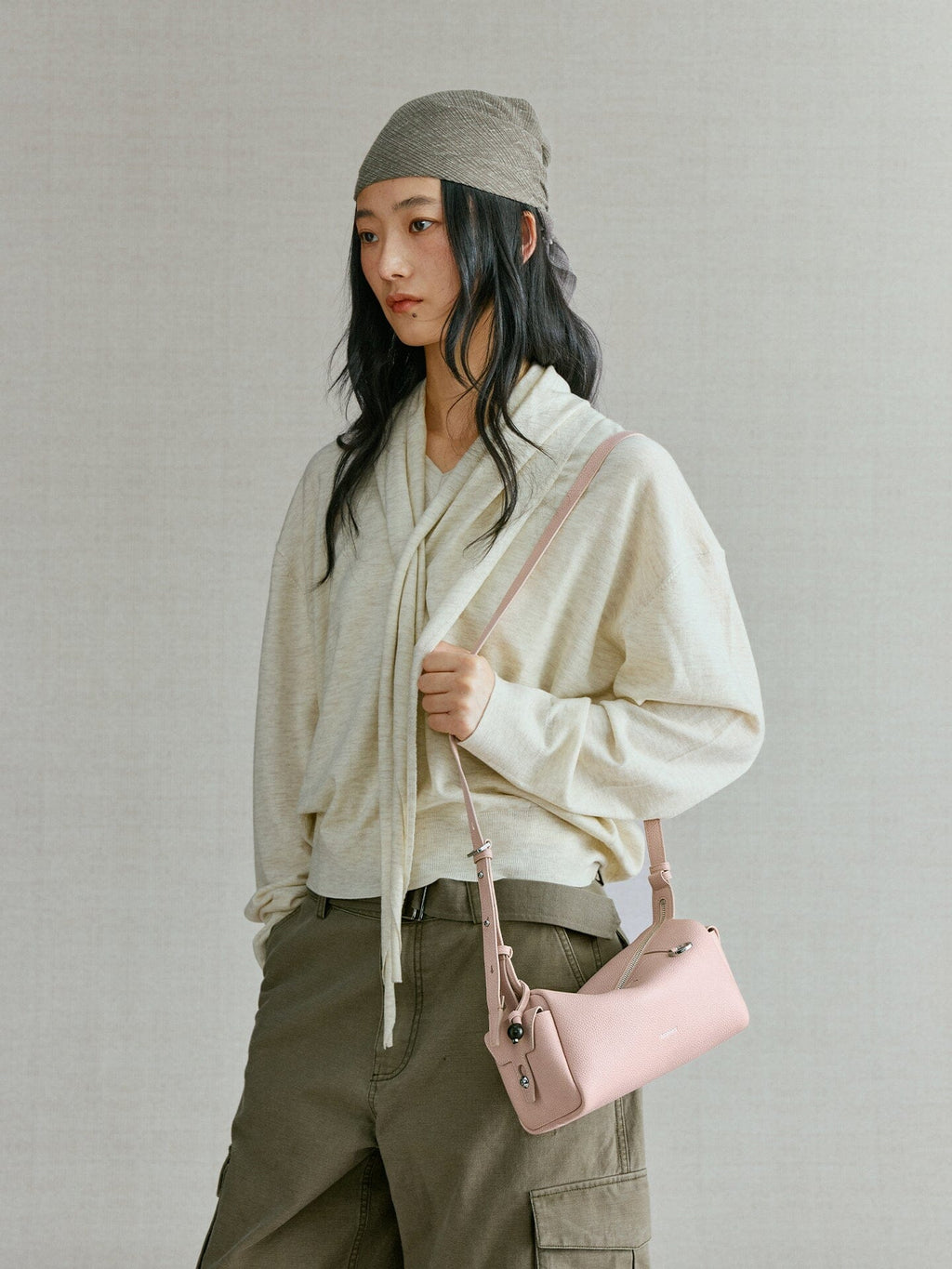 Songmont Mini Yore Camera Bag Peach - worn cross-body with a cream knit and cargo trousers