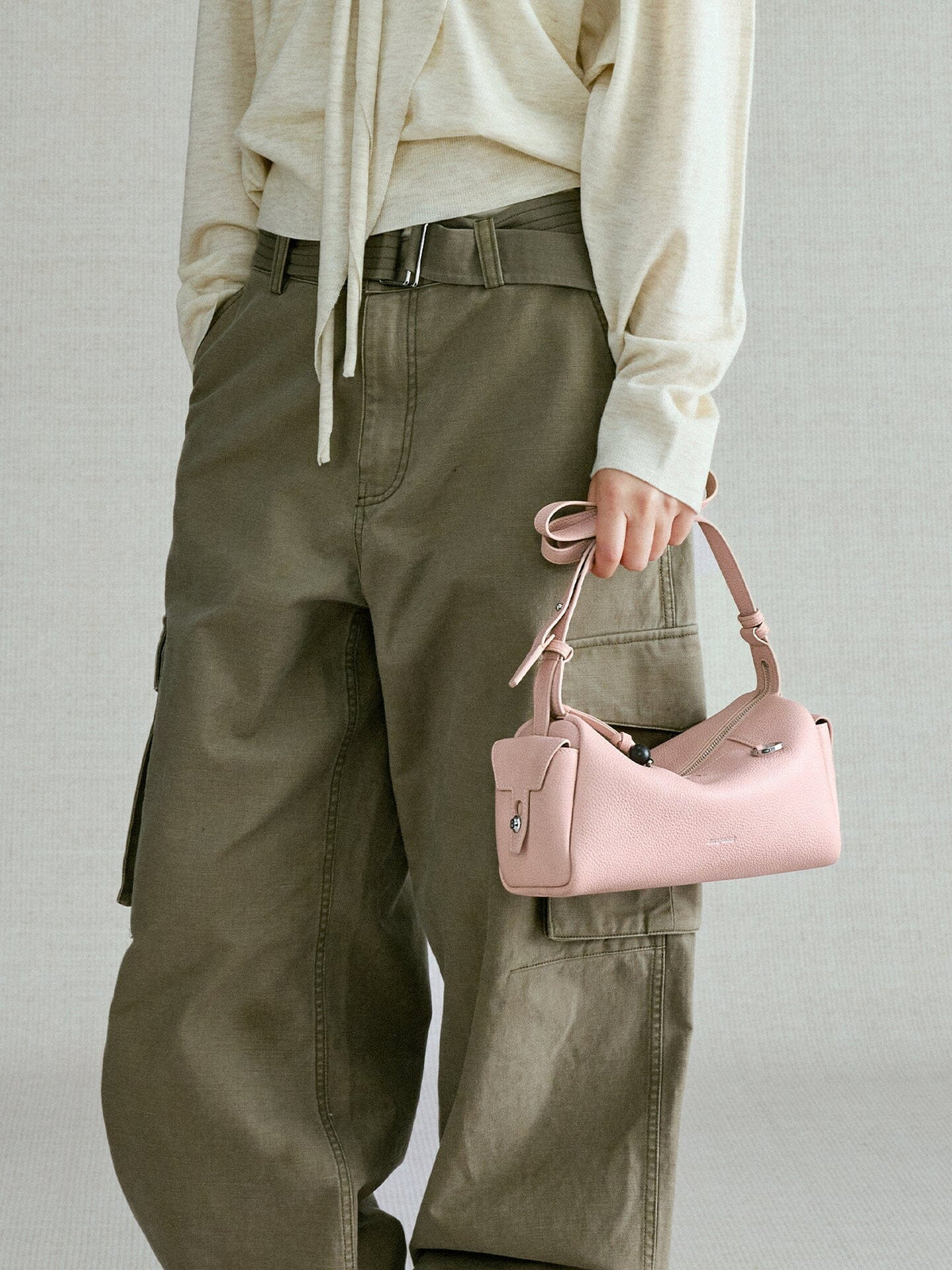 Songmont Mini Yore Camera Bag Peach - carried by the strap in one hand