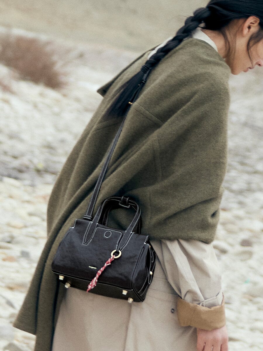 Songmont Mini Yore Duffle Bag Onyx - worn cross-body with an olive wrap