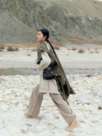 Songmont Mini Yore Duffle Bag Onyx - cross-body on a model walking a rocky landscape