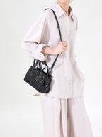 Songmont Mini Yore Duffle Bag Onyx - cross-body strap over a cream shirt