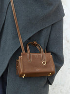 Songmont Mini Yore Duffle Bag Sandal - worn cross-body against a grey wool coat