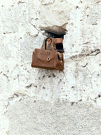 Songmont Mini Yore Duffle Bag Sandal - bag set against a white stone wall