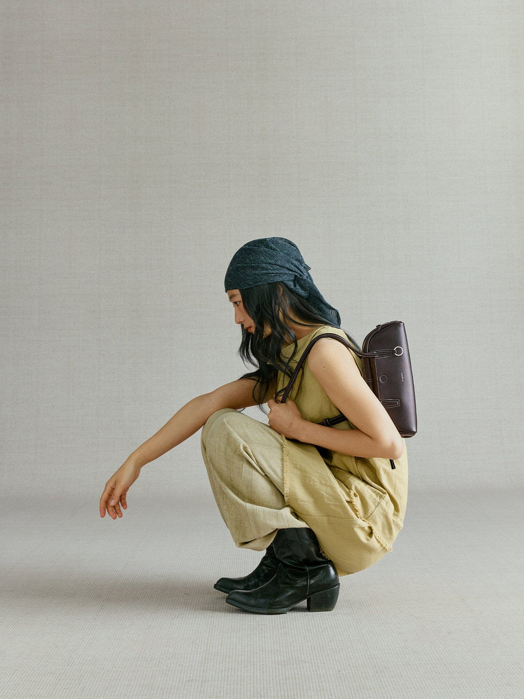Songmont Mini Yore Toast Bag Ebony - worn by model, crouching with the bag on her back