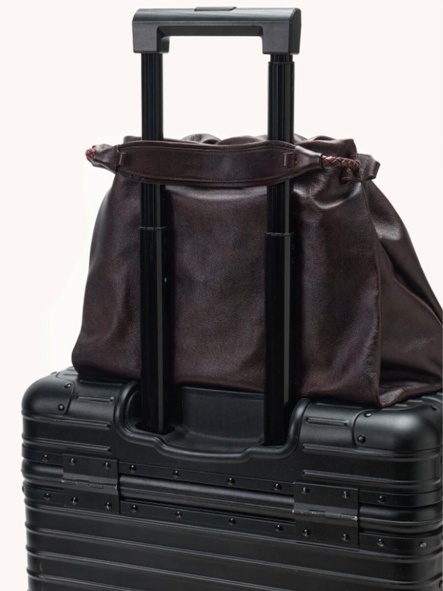 Songmont Small Gather Bag Ebony - on a suitcase handle