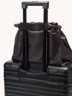 Songmont Small Gather Bag Ebony - on a suitcase handle