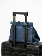 Songmont Small Gather Bag Navy - on a suitcase handle