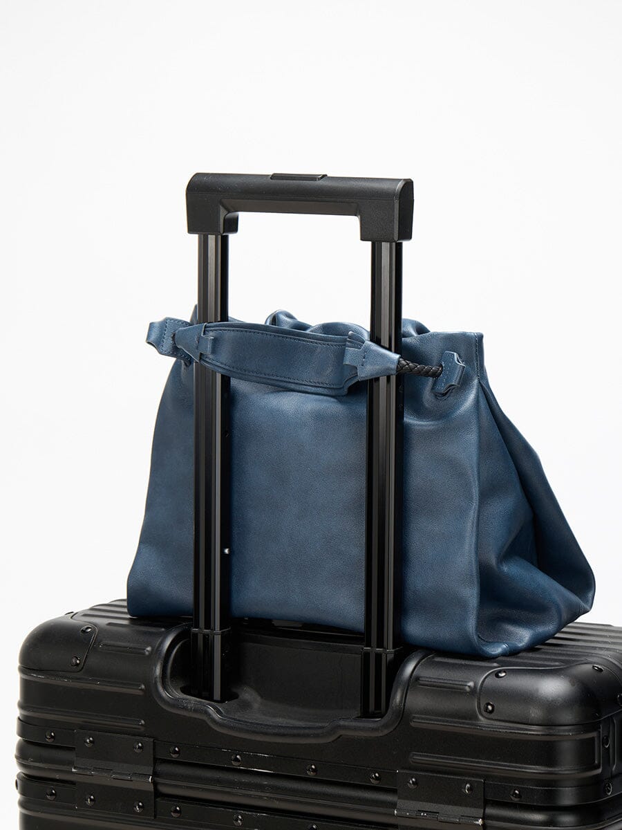 Songmont Small Gather Bag Navy - on a suitcase handle