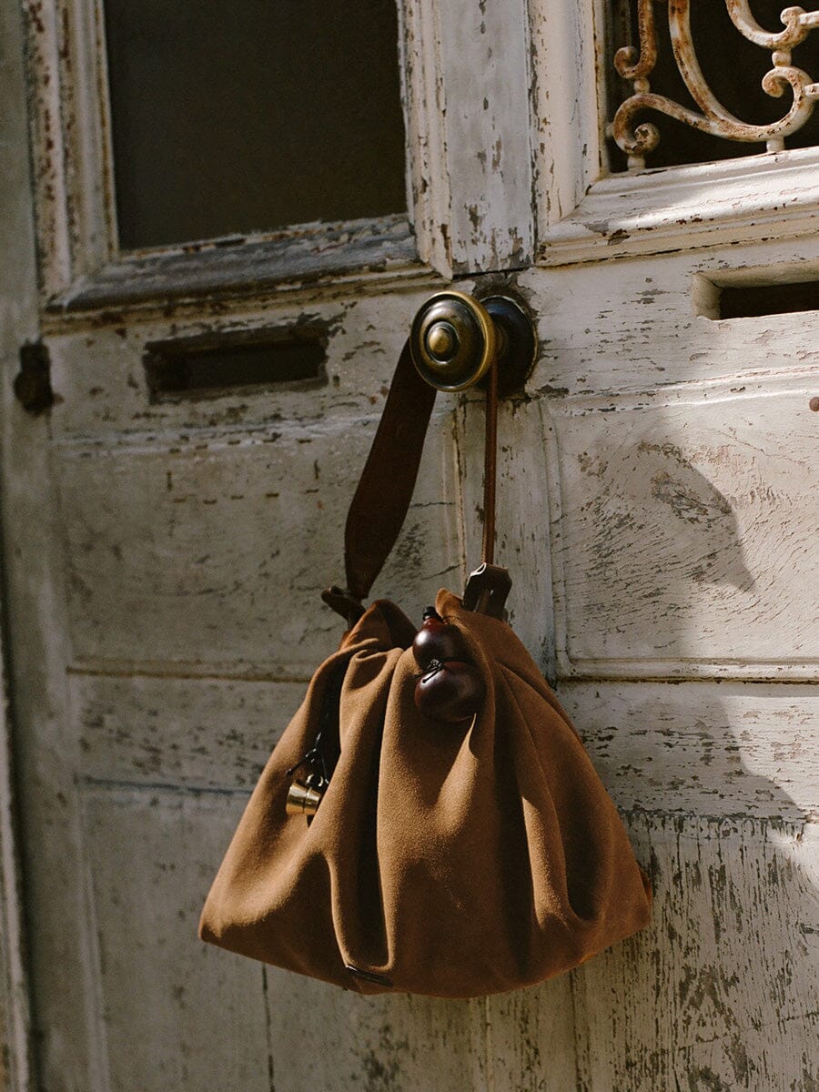 Songmont Small Gather Bag Ochre Suede - hanging from a door handle