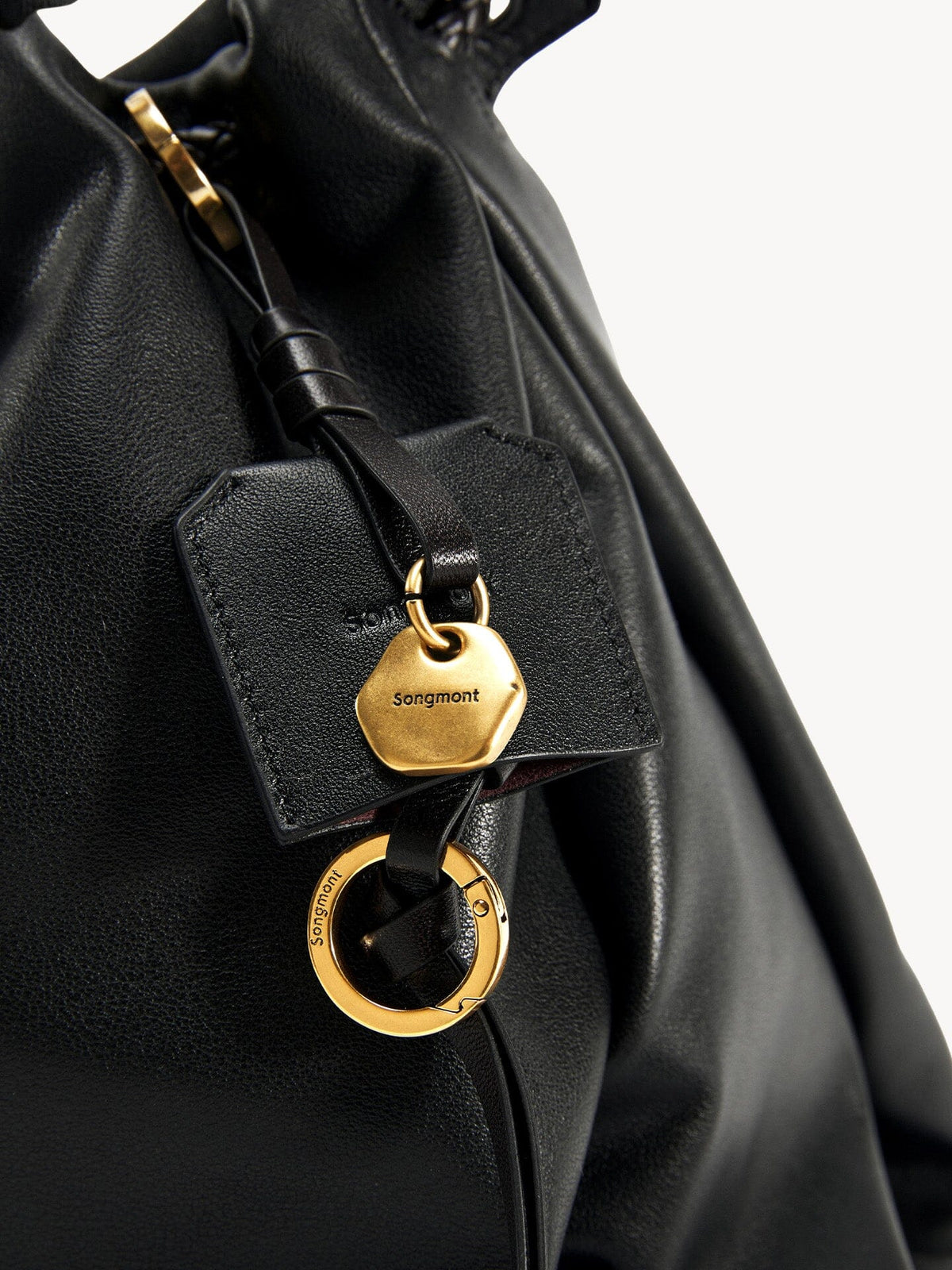 Songmont Small Gather Bag Onyx charm and gold hardware detail