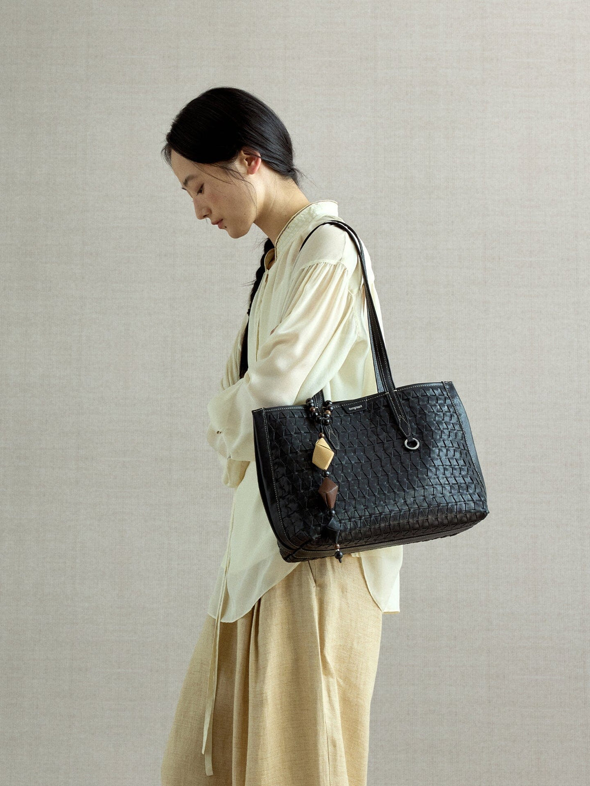 Songmont Small Lattice Tote Onyx - worn on the shoulder