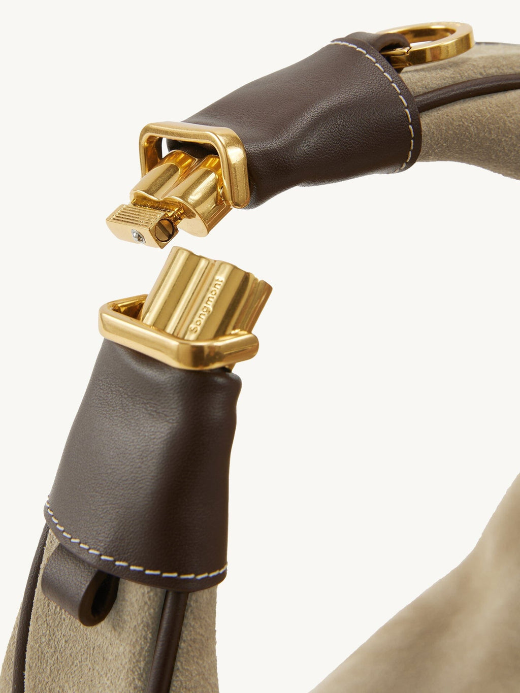 Songmont Medium Luna Hobo Bag Dune Suede - gold clasp and brown leather tab close-up