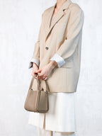 Songmont Small Song Bag Cream Apricot - carried by the top handles