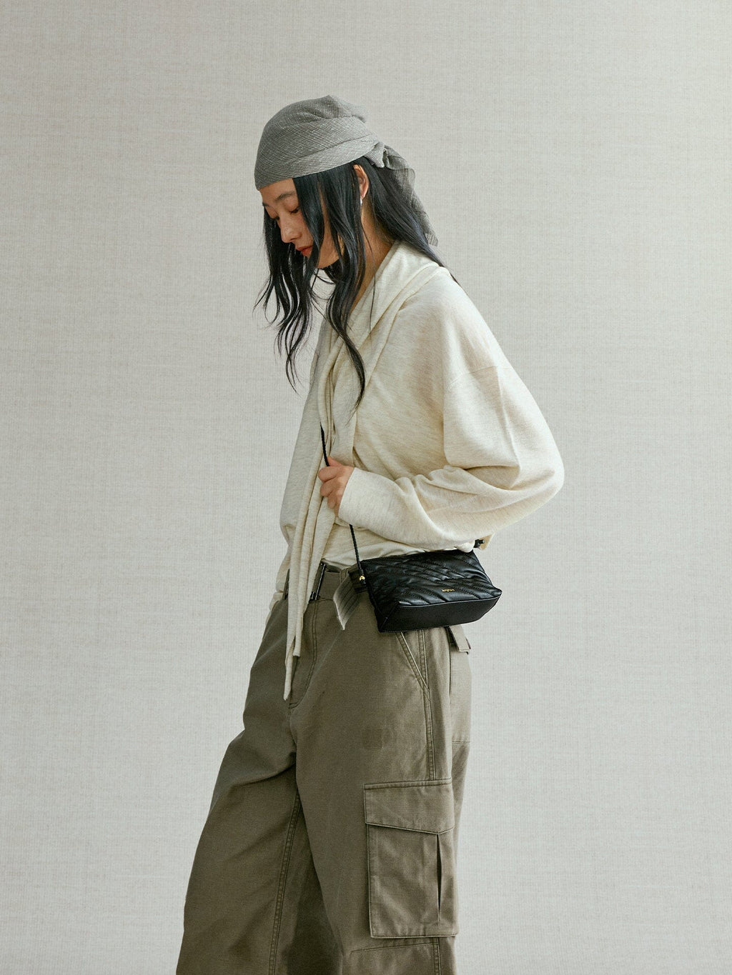 Songmont Winding Underarm Bag Onyx - worn on the body, side view with headscarf