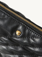 Songmont Winding Underarm Bag Onyx - close-up of gold zip and stud on quilted leather