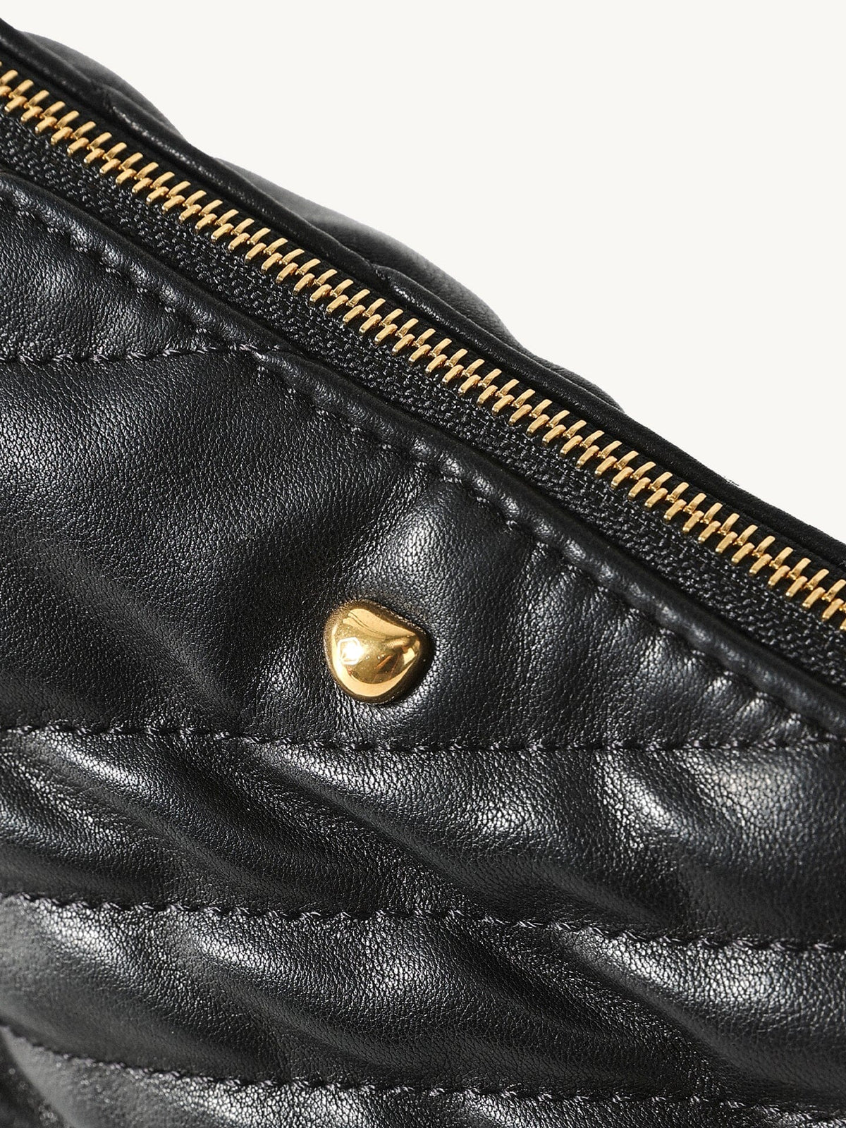 Songmont Winding Underarm Bag Onyx - close-up of gold zip and stud on quilted leather