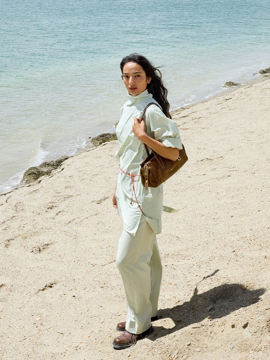 Songmont Yore Baguette Bag Sandal worn on the shoulder at the beach
