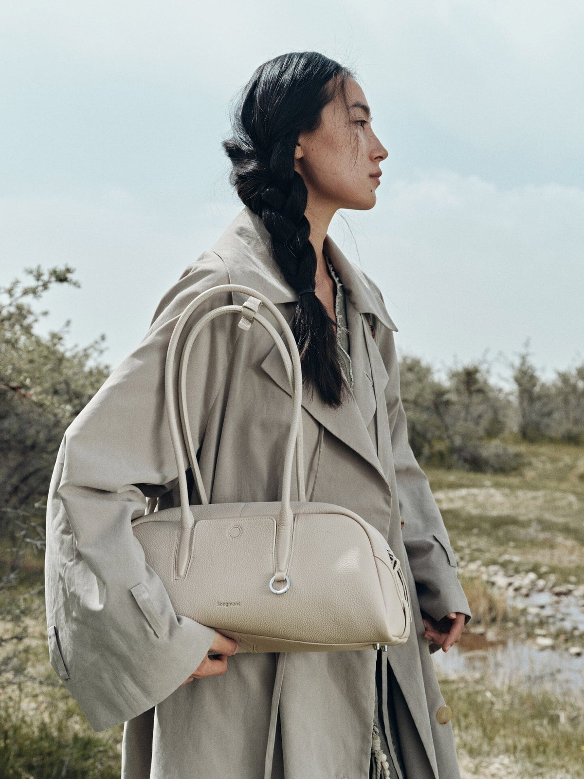Songmont Yore Toast Bag Cloud - carried at the front with a grey trench coat